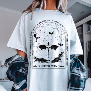 May include: White t-shirt with a black graphic print of a dragon with the text "A dragon without its rider is a tragedy. A rider without their dragon is dead. Fourth Wing."