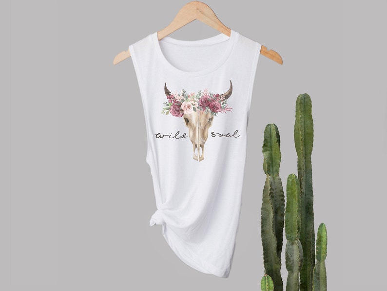 May include: White sleeveless tank top with a floral skull graphic and the text "wild soul".