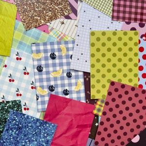 May include: A vibrant collection of patterned paper sheets. Designs include polka dots, gingham, stripes, and fruit patterns. Colours range from pink, blue, and green to gold glitter and red. Suitable for scrapbooking, card making, or other craft projects.