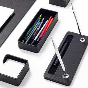May include: Black leather desk organizer set with a pen holder, pencil holder, and note pad holder.