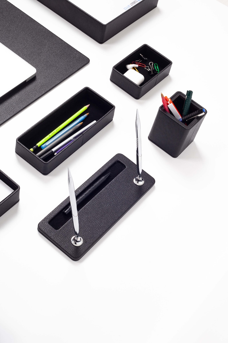 May include: Black leather desk organizer set with a pen holder, pencil holder, and a tray for paper clips.