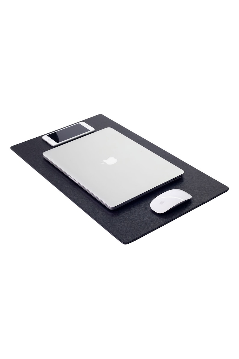 May include: A black desk mat with a laptop, a smartphone, and a white wireless mouse on top.