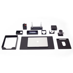May include: A black desk organizer set with a laptop, a pen holder, a tray for pens, a note holder, a business card holder, a letter tray, a mouse pad, and a cup holder.