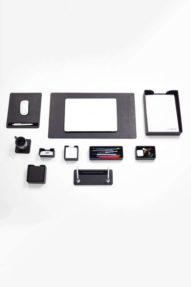 May include: A black desk organizer set with a laptop mat, a pen holder, a pencil holder, a small tray, a mouse pad, and a letter tray.