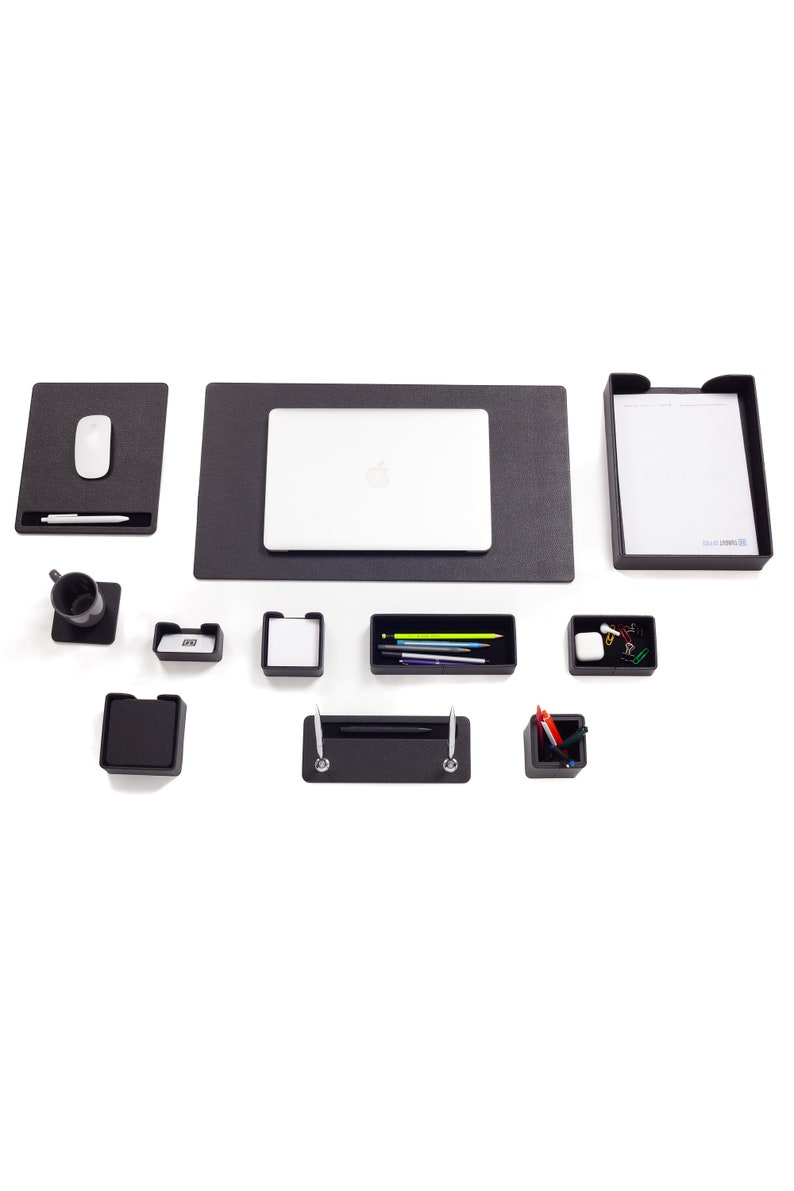 May include: A black desk organizer set with a laptop, a mouse, a pen holder, a pencil holder, a tray, and a notepad. The set is on a white background.