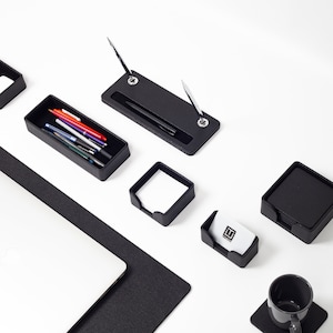 May include: Black leather desk organizer set with a pen holder, business card holder, note pad holder, and a cup holder. The set also includes a black leather desk mat.