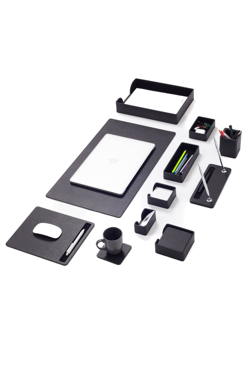 May include: Black leather desk organizer set with a laptop mat, mouse pad, pen holder, cup coaster, and various trays for organizing office supplies.