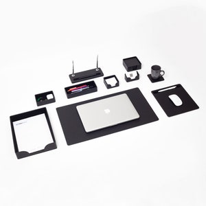 May include: Black desk organizer set with a laptop, pen holder, note pad holder, business card holder, and a cup holder. The set is on a black desk mat.