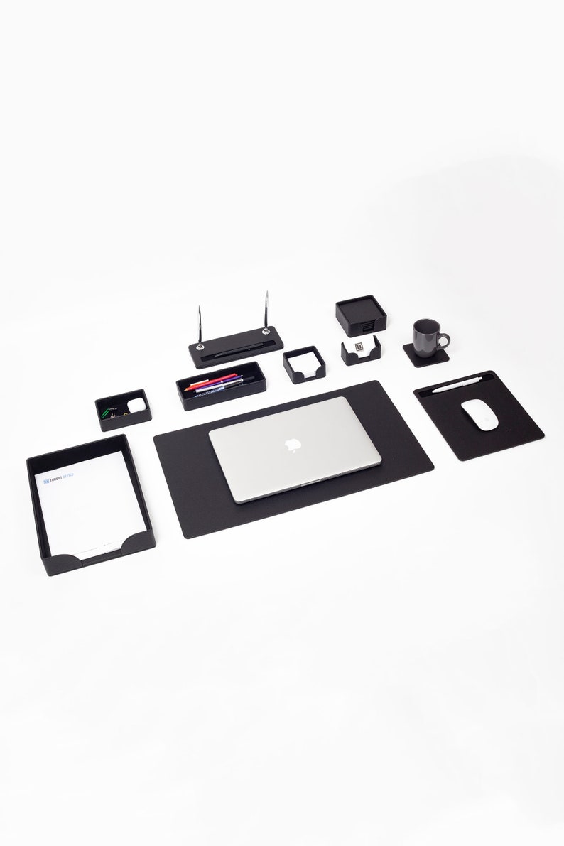 May include: Black desk organizer set with a laptop, pen holder, note pad holder, business card holder, and a cup holder. The set is on a black desk mat.