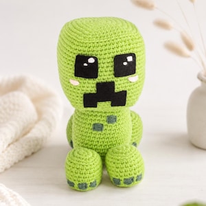 Può includere: Bambola Creeper verde all'uncinetto fatta a mano con occhi e bocca neri e piccole guance rosa. Il peluche ha testa e corpo quadrati, con gambe e braccia arrotondate. Personaggio popolare del videogioco Minecraft.