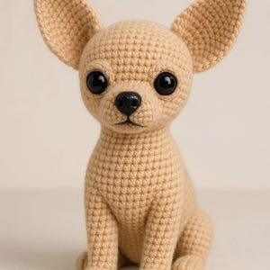 Può includere: Figurina di cane chihuahua all'uncinetto in posizione seduta. Il cane è color beige con grandi occhi neri e un naso nero. Le orecchie sono grandi e dritte. La figurina è fatta a mano e ha un aspetto strutturato.