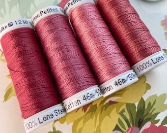 May include: Four spools of Sulky 12wt cotton thread in a dusty rose color. The spools are labeled "100% Long Staple Cotton 46m/50m".