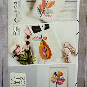 May include: A promotional image featuring home decor items with a botanical theme. The image includes a pillow, tote bag, and framed artwork, all showcasing colorful leaf and petal designs. The text "PETAL POP" and "ZEN CHIC" are visible.