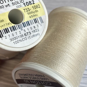 May include: A spool of Sulky Cotton 30 thread in color 1082, a light beige color. The spool is labeled "Sulky Cotton 30, 30 wt. Solid, col: 1082, 733-1082, 500yds, 450m, 100%CO (Cotton)".