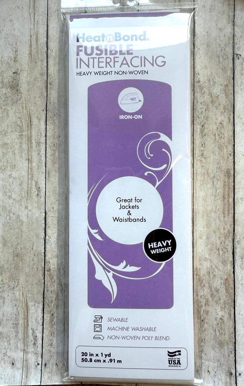 Op de afbeelding: Een verpakking HeatnBond strijkbare tussenvoering, zware kwaliteit vlieseline. De wit-paarse verpakking bevat de tekst Great for Jackets & Waistbands, sewable, machine washable en de afmetingen 50,8 cm x 0,91 m.
