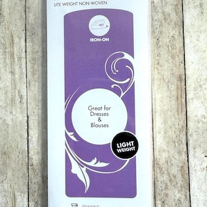 Op de afbeelding: Een verpakking HeatnBond strijkbare tussenvoering, een lichtgewicht non-woven materiaal. De wit-paarse verpakking bevat de tekst Iron-On, Great for Dresses & Blouses en Light Weight. Het meet 50,8 cm bij 0,91 m.