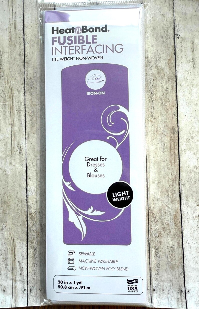 Op de afbeelding: Een verpakking HeatnBond strijkbare tussenvoering, een lichtgewicht non-woven materiaal. De wit-paarse verpakking bevat de tekst Iron-On, Great for Dresses & Blouses en Light Weight. Het meet 50,8 cm bij 0,91 m.