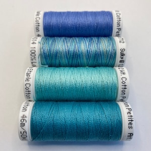 May include: Four spools of thread in shades of blue and teal. The spools are labeled with the brand name "Sulky" and the thread weight "122Wt."