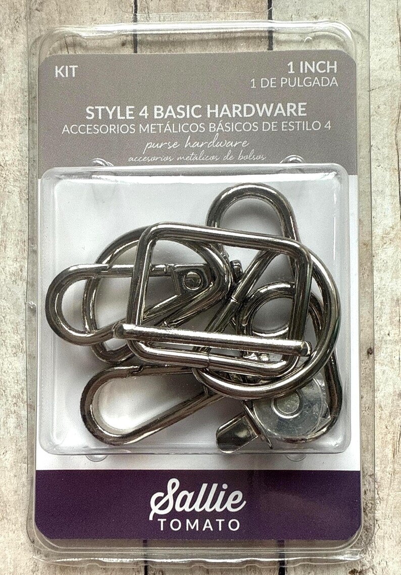 May include: A kit of silver-coloured metal purse hardware in a clear plastic package labelled Style 4 Basic Hardware, 1 Inch. The set includes several lobster claw clasps and rectangular rings for bag construction, visible through the clear blister pack.