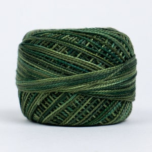 Op de afbeelding: Een spoel met groene en bruine borduurgaren.
