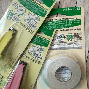May include: An assortment of Clover brand sewing tools, including fusible bias tape makers and fusible web tape. The packaging is green and white, with product details and instructions. The tools are yellow and pink.