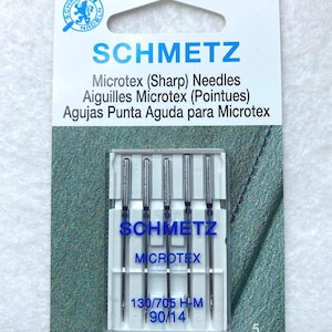 May include: A package of 5 Schmetz Microtex sewing machine needles in a clear plastic case. The needles are silver and have a blue label that says "Schmetz Microtex" and "130/705 H-M 90/14".