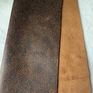 May include: Two pieces of leather, one brown and one dark brown with a textured surface.
