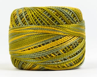 Puede incluir: Una bobina de hilo de bordar verde y amarillo.