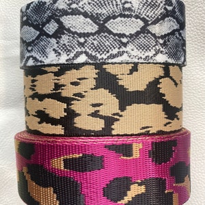 May include: Three rolls of patterned webbing, one with a snake skin pattern, one with a camouflage pattern, and one with a leopard print pattern.