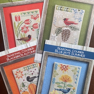 May include: Four cross-stitch patterns with seasonal themes. Each pattern is framed and features a different bird and season: Robin's Spring, Cardinal's Winter, Blackbird's Autumn, and Blue Jay's Summer. The patterns include floral and natural elements.