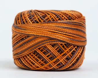 May include: A spool of brown and orange embroidery floss.