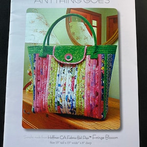May include: Aunties Two Patterns "Anything Goes" pattern cover. The image shows a colorful, handmade tote bag with a green flap and handles. The bag is approximately 15 inches tall, 15 inches wide, and 8 inches deep. The cover includes the text "Fringe Blossom".