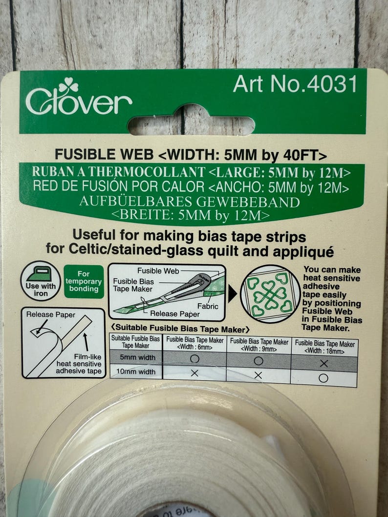 May include: A package of Clover fusible web for making bias tape strips. The package is green and white, with text indicating a 5mm width and 40ft length. Instructions and diagrams are included for use with an iron and fabric.