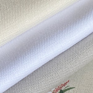 May include: Three different fabric swatches in various shades of gray. The top swatch is a light beige, the middle swatch is white, and the bottom swatch is a medium gray.