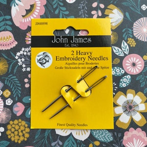 May include: Package of two heavy embroidery needles from John James, a brand established in 1840. The package is yellow with black text and a dragon logo. The needles are displayed on a yellow card.