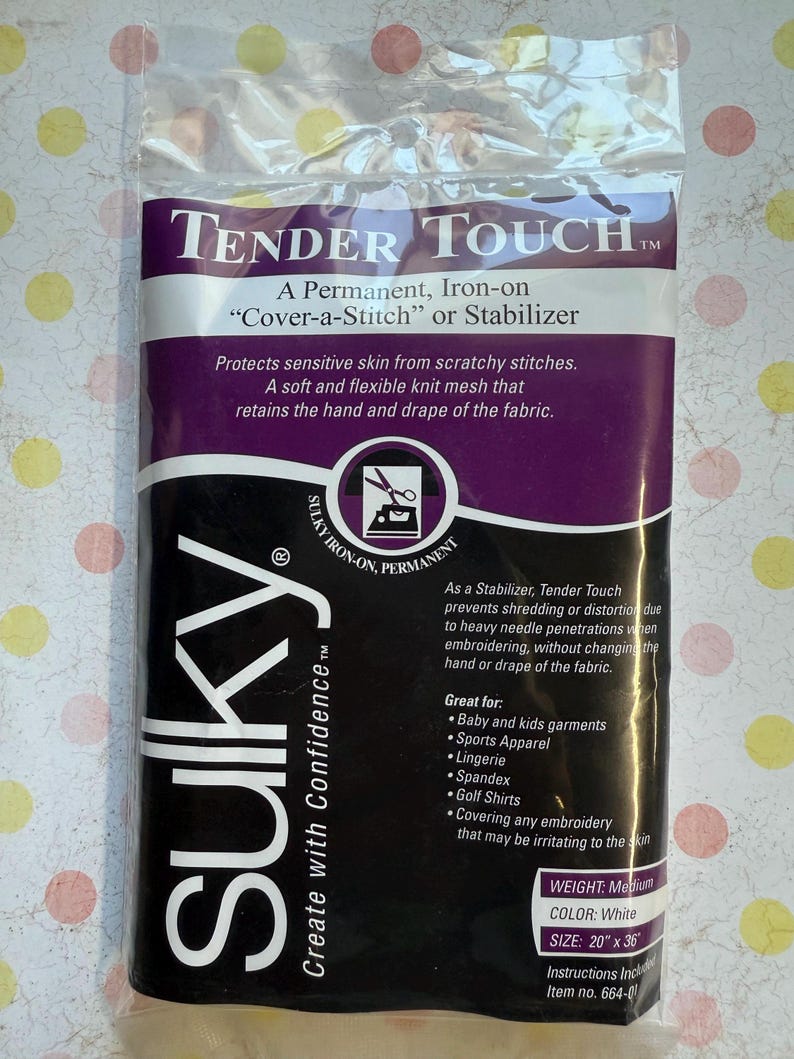 May include: A package of Sulky Tender Touch stabilizer. The package is black and purple with white text, including "Tender Touch" and "Sulky." The stabilizer is white, measures 20" x 36", and is designed to protect sensitive skin from scratchy stitches.