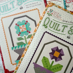 May include: Three quilting pattern books with the title "Quilt Seeds" and "Quilts" with a flower design on the cover. The books are by Lori Holt of Bee in my Bonnet and Piece & Plenty.