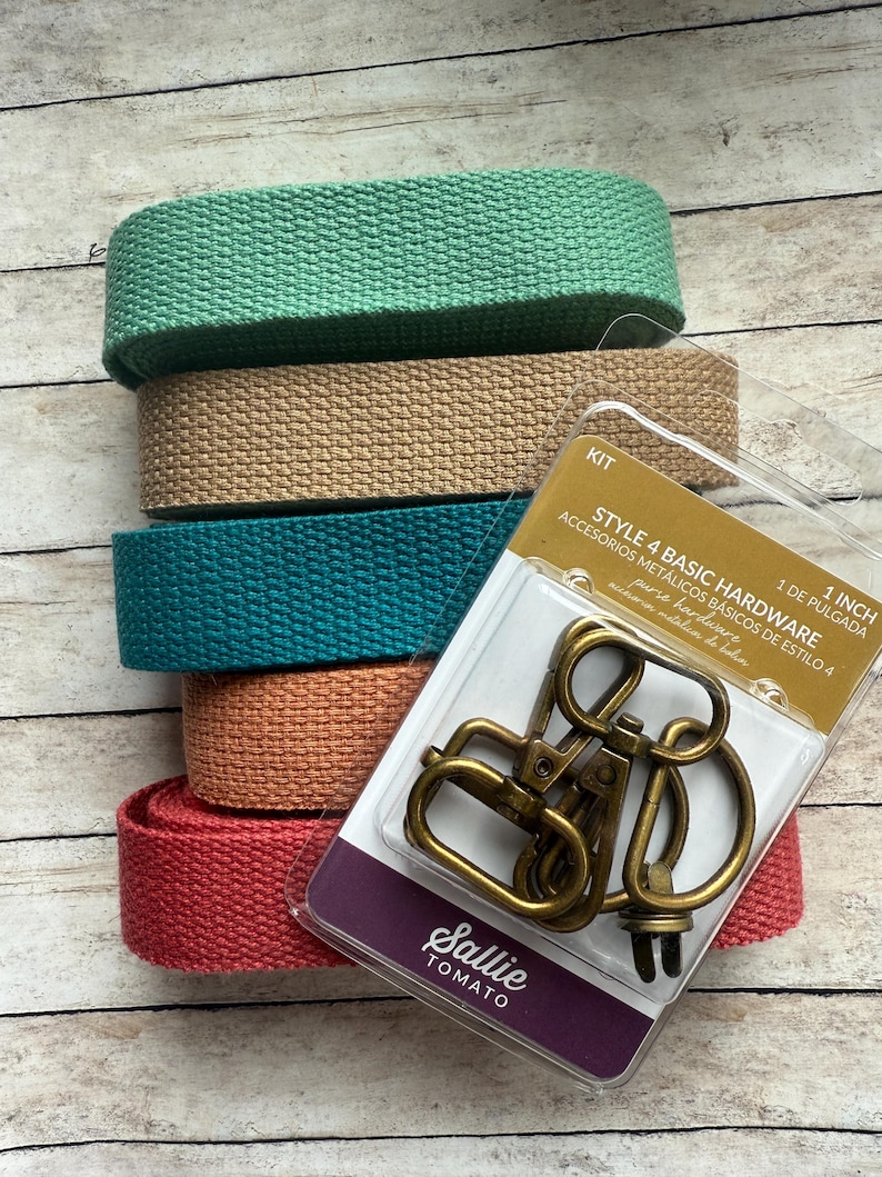 May include: A stack of five rolls of woven cotton webbing in mint green, tan, teal, peach, and coral, paired with a Sallie Tomato Style 4 Basic Hardware kit containing antique brass swivel hooks and D-rings for 1 inch wide straps.