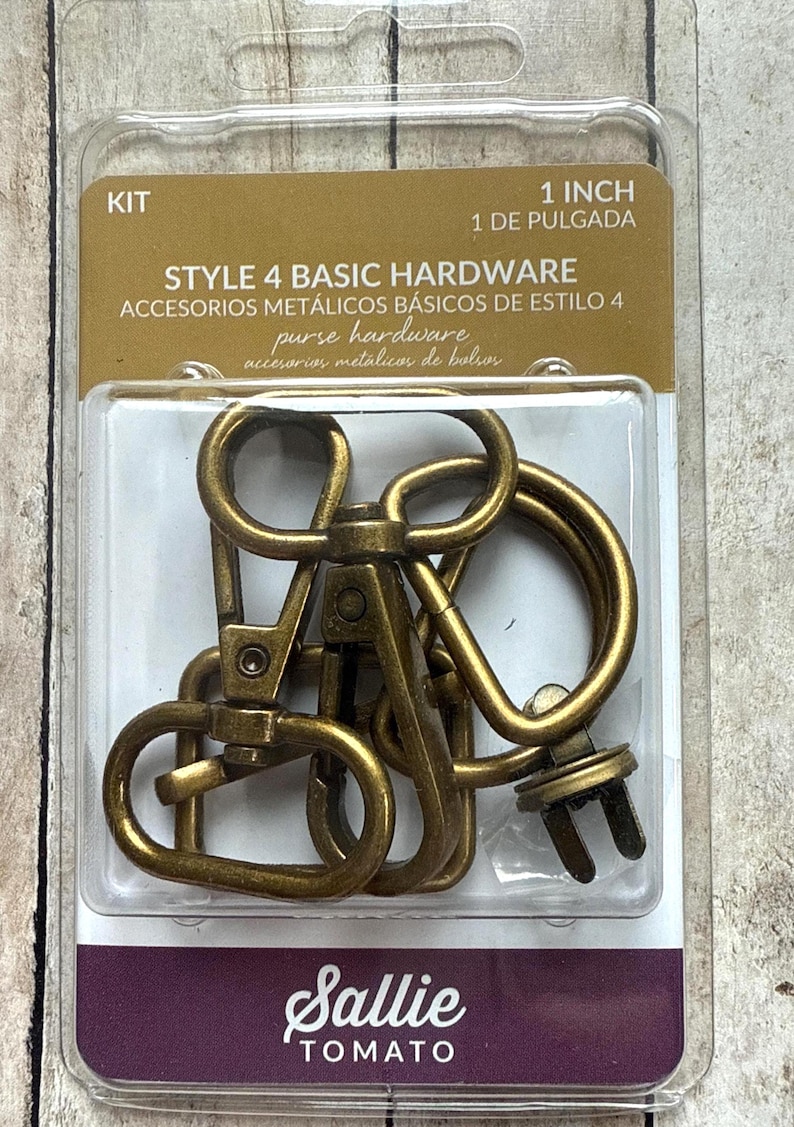 May include: A Sallie Tomato Style 4 Basic Hardware kit containing antique brass-coloured metal purse hardware, including swivel lobster clasps and D-rings, packaged in a clear plastic blister pack labelled 1 inch for bag making projects.
