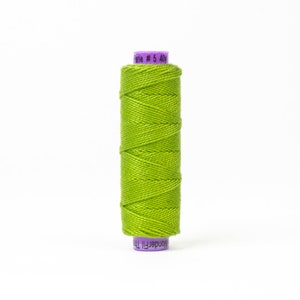 Puede incluir: Una bobina de hilo verde brillante con una etiqueta morada que dice "WonderFil 100%  Serie # 5 40y".