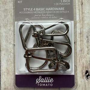 May include: A Sallie Tomato Style 4 Basic Hardware kit containing silver-coloured metal purse hardware, including swivel lobster clasps and a rectangular slider buckle. The packaging is labelled 1 inch and includes multiple metal components.