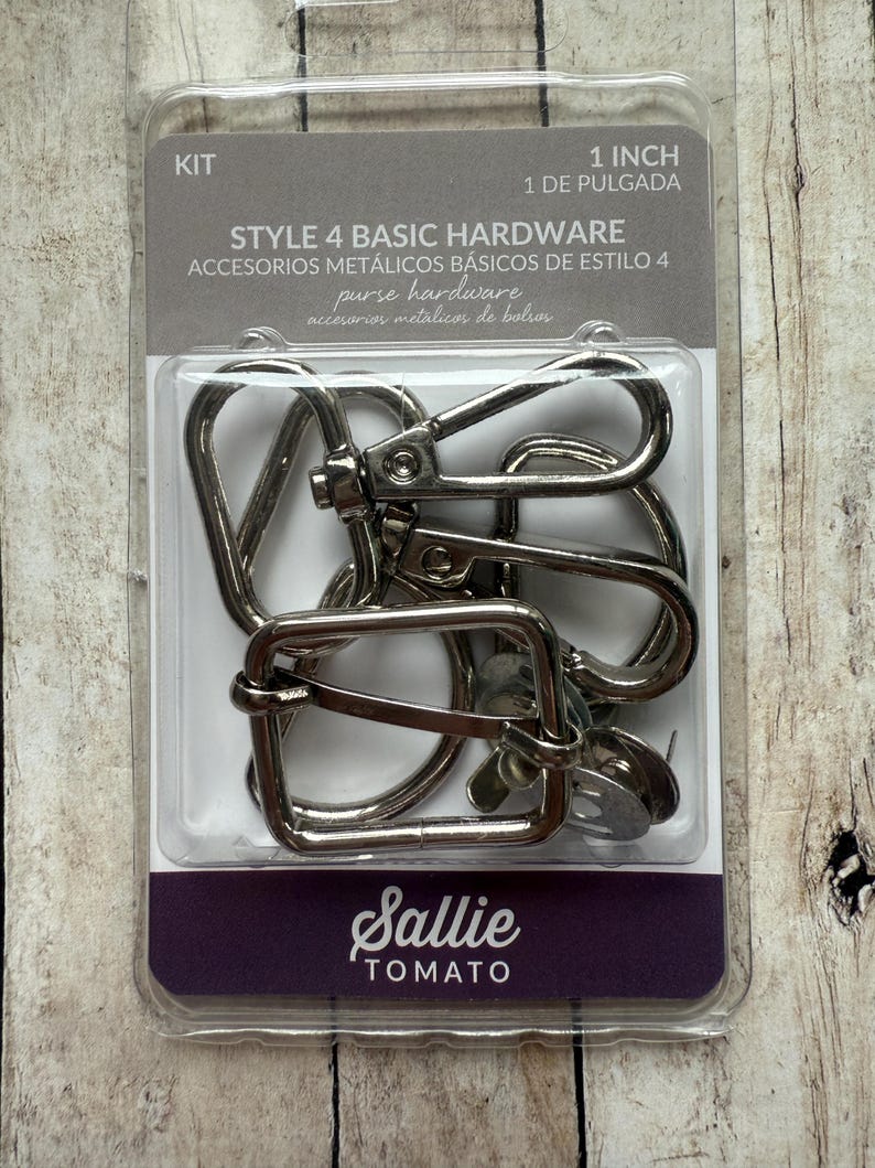 May include: A Sallie Tomato Style 4 Basic Hardware kit containing silver-coloured metal purse hardware, including swivel lobster clasps and a rectangular slider buckle. The packaging is labelled 1 inch and includes multiple metal components.