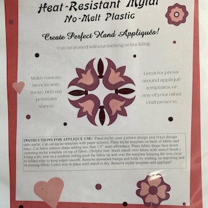 May include: Five 8.5 by 11 inch sheets of heat-resistant mylar plastic. The packaging shows a pink heart, a floral design, and instructions for using the mylar to create appliqués. The text on the packaging reads "Heat-Resistant Mylar No-Melt Plastic Create Perfect Hand Appliqués! Can be ironed without melting or buckling."