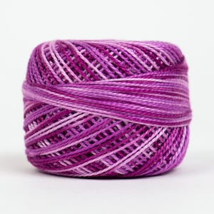 May include: A spool of purple and white embroidery floss.