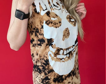 May include: A brown and black tie-dye sleeveless shirt with a white skull and the word "Misfits" printed on the front.