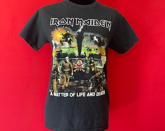 May include: Black t-shirt with a graphic print of a tank and soldiers. The text "Iron Maiden" and "A Matter of Life and Death" are printed on the shirt.