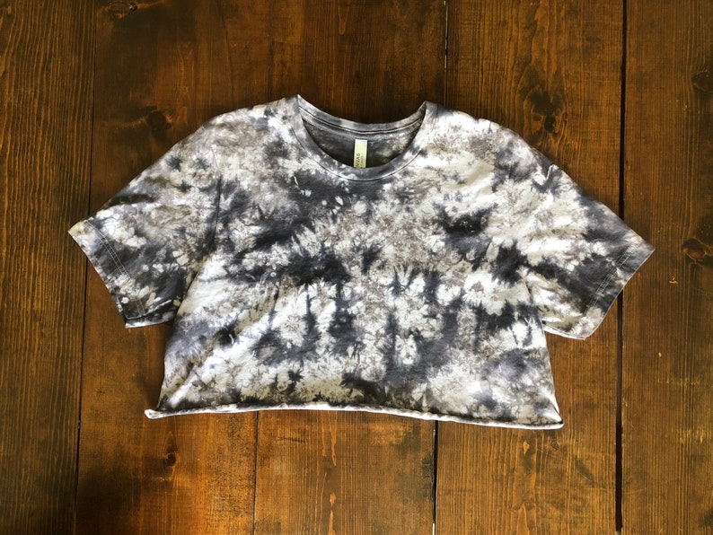 May include: A cropped, short-sleeved t-shirt with a tie-dye pattern in shades of gray and white.