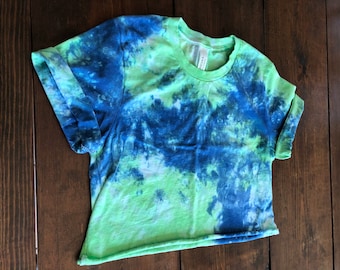 May include: A green and blue tie-dye cropped t-shirt with a crew neck.