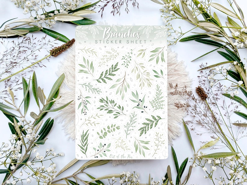 Op de afbeelding: Een stickerblad met een witte achtergrond en verschillende groene aquareltakken en bladeren. Het blad is getiteld "Branches Sticker Sheet" en heeft de tekst "Out of the Pen" onderaan.