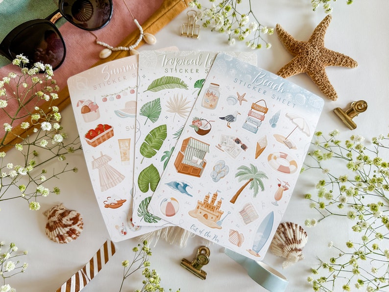 May include: Three sticker sheets with summer themes. The sheets are white with colorful illustrations of tropical leaves, beach scenes, and summer activities. The text on the sheets reads "Summer Sticker Sheet", "Tropical Leaves Sticker Sheet", and "Beach Sticker Sheet".
